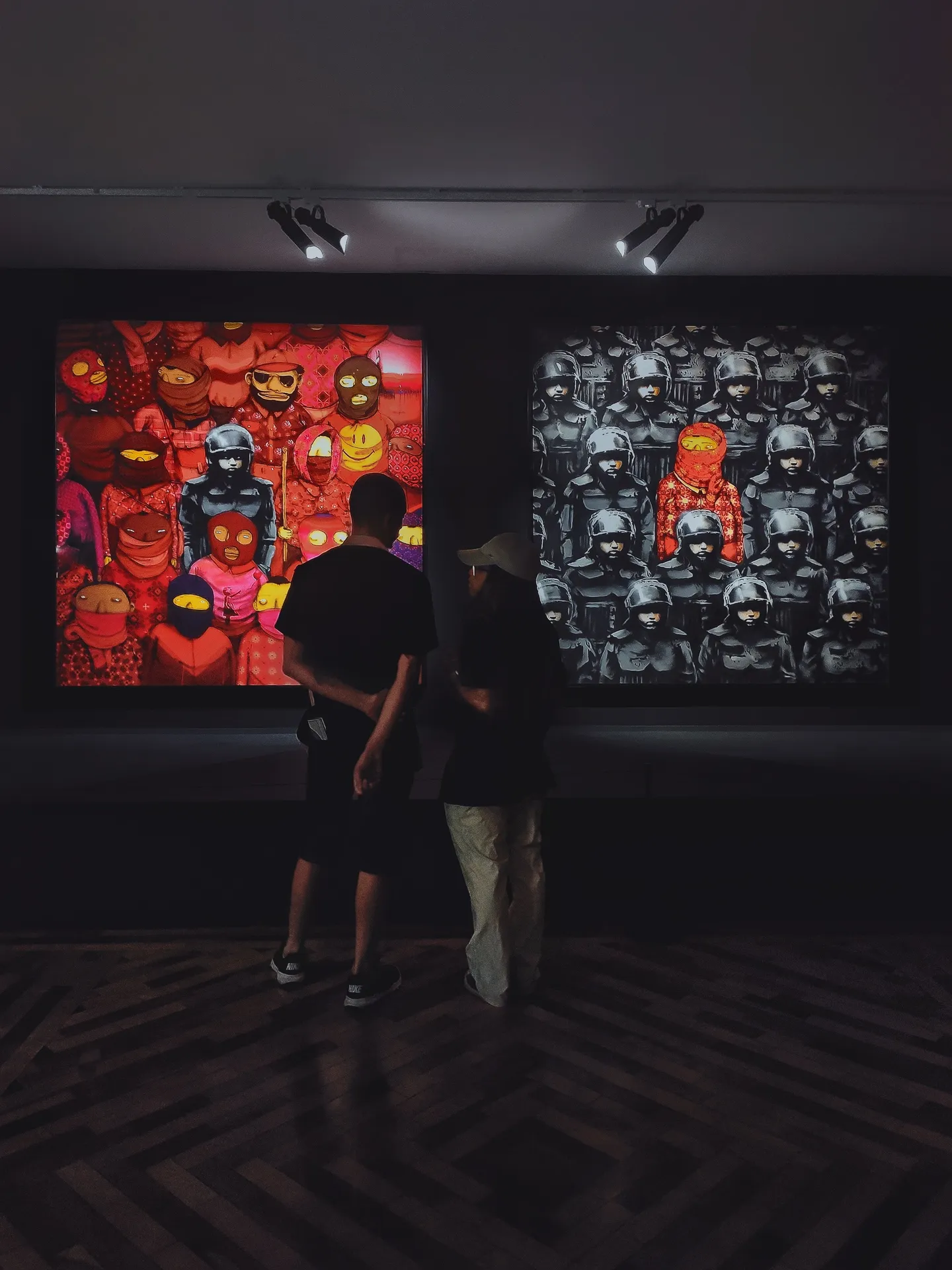 Due visitatori osservano le opere esposte in una galleria.