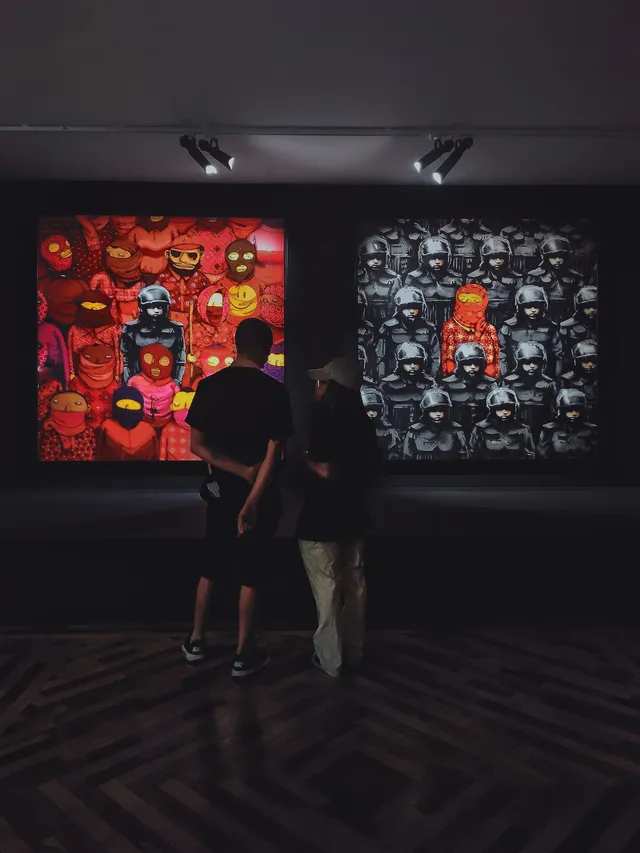 Due visitatori osservano le opere esposte in una galleria.