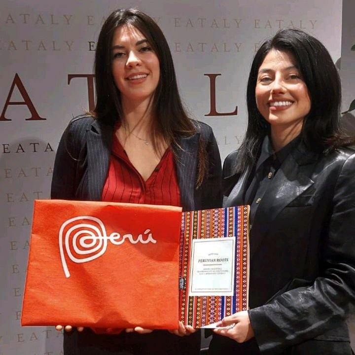 Due partecipanti mostrano il ricettario Peruvian Roots.