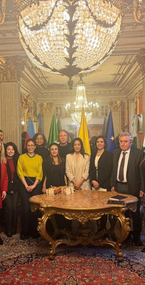Foto di gruppo nella sala dell’Ambasciata della Colombia, davanti alle bandiere.